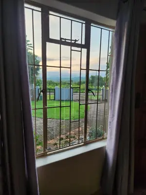a window with a view of a park through it at View on 83 in Tzaneen