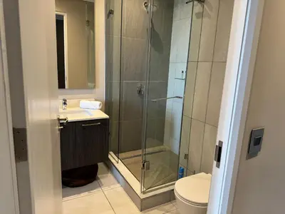a bathroom with a shower and a toilet and a sink at Menlyn Maine Triology - 10 On Capital in Pretoria