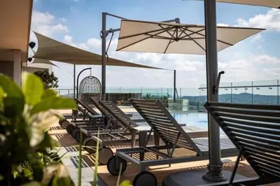 a row of chairs and an umbrella on a patio at Menlyn Maine Triology - 10 On Capital in Pretoria