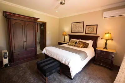 a bedroom with a large bed and two lamps and aoire at MacGregors Guest House in Pretoria