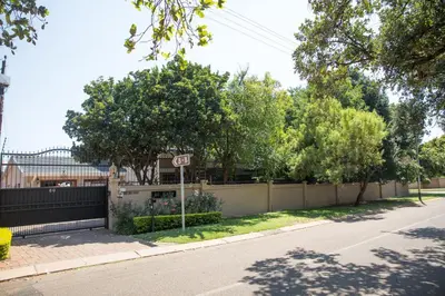 a street with a fence and a stop sign at MacGregors Guest House in Pretoria