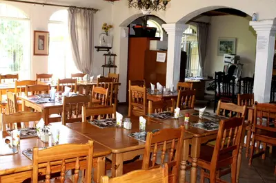 a dining room with wooden tables and chairs at Airport Lodge Guest House in Kempton Park