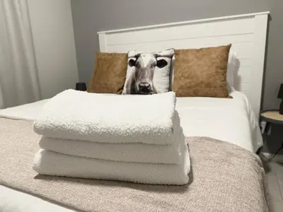 a pile of towels with a cow head on a bed at Shamah in Pretoria