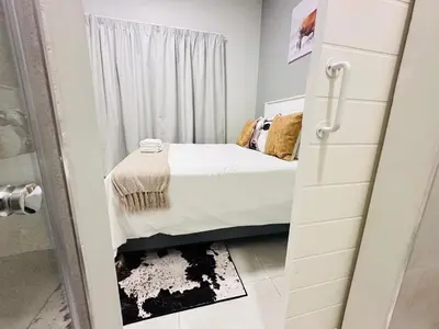 a small bedroom with a bed and a shower at Shamah in Pretoria