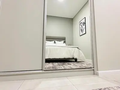 a mirror in a bedroom with a bed at Shamah in Pretoria