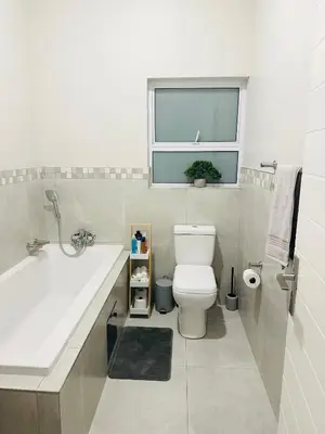 a bathroom with a sink and a toilet and a window at Shamah in Pretoria