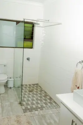 a bathroom with a shower with a toilet and a sink at The Good Host in Waterval-Onder
