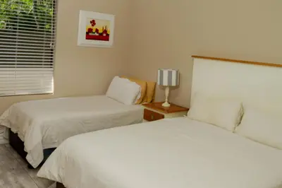 a bedroom with two beds and a window at The Good Host in Waterval-Onder