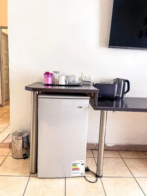 a table with a counter top and a refrigerator at Bobisemo Luxury Guesthouse in Pretoria