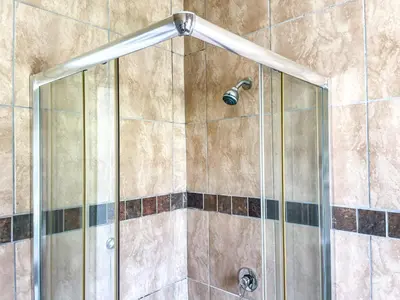 a shower with a glass door with a shower head at Bobisemo Luxury Guesthouse in Pretoria