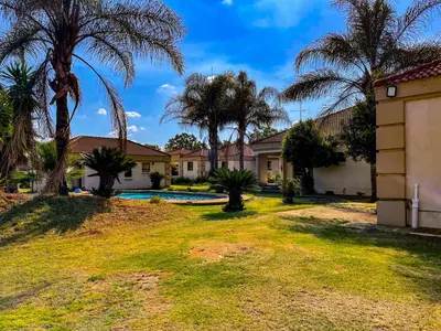 a house with palm trees and a swimming pool at Bobisemo Luxury Guesthouse in Pretoria