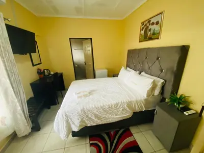 a bedroom with a large bed with white sheets at Lalamnandzi 4 in White River