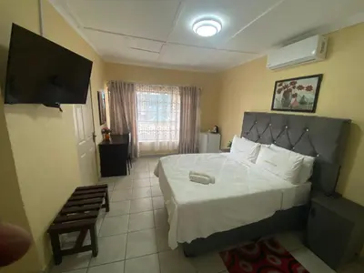 a bedroom with a bed and a chair in it at Lalamnandzi 4 in White River