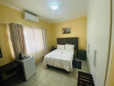 a bedroom with a white bed and a window at Lalamnandzi 4 in White River