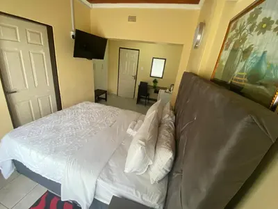 a bedroom with a white bed and a couch at Lalamnandzi 4 in White River