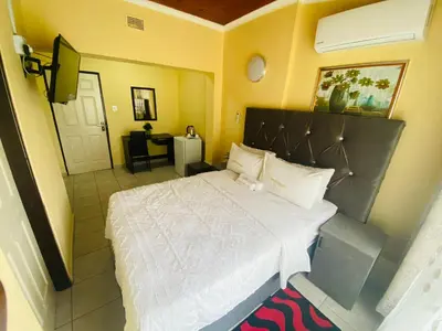 a bedroom with a large bed and a television at Lalamnandzi 4 in White River