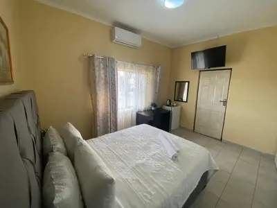 a bedroom with a white bed and a window at Lalamnandzi 4 in White River