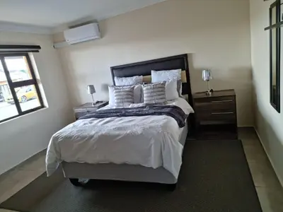 a bedroom with a large bed with white sheets and pillows at Lasev guesthouse in Pretoria