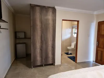 a large wooden cabinet in a room with a toilet at Lasev guesthouse in Pretoria