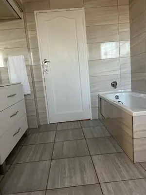 a bathroom with a white door and a tub at Lebamboo On Protea in Pretoria