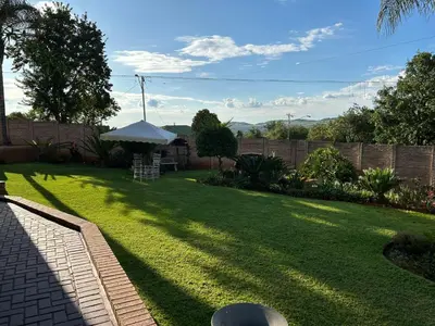 a lawn with an umbrella in a backyard at Lebamboo On Protea in Pretoria