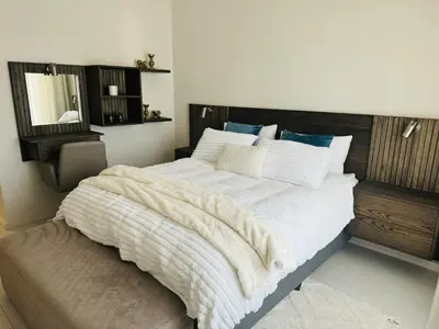 a bedroom with a large bed with a wooden headboard at Luxury 3 Bedroom Apartment in Carlswald in Erand