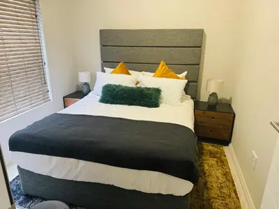 a bedroom with a large bed with yellow pillows at Luxury 3 Bedroom Apartment in Carlswald in Erand