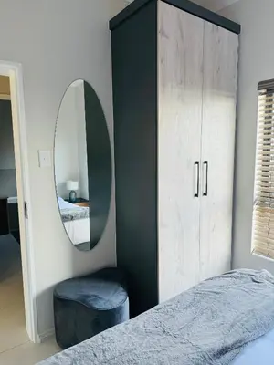 a bedroom with a large wardrobe and a mirror at Luxury 3 Bedroom Apartment in Carlswald in Erand