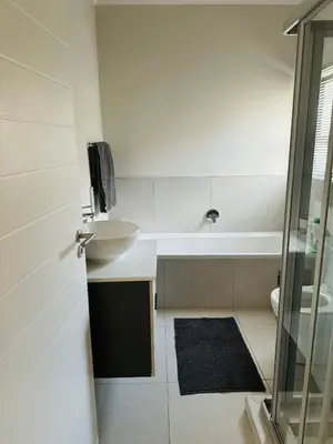 a bathroom with a sink and a bath tub at Luxury 3 Bedroom Apartment in Carlswald in Erand