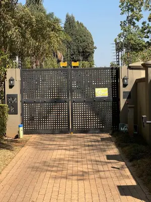 a black fence with a gate with a brick driveway at BLessing at Lynnwood in Pretoria