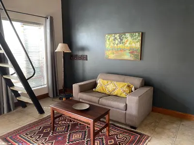a living room with a couch and a table at BLessing at Lynnwood in Pretoria