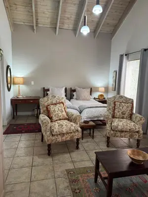 a living room with a bed and two chairs at BLessing at Lynnwood in Pretoria