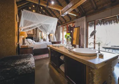 a bathroom with a sink and a bed in a room at Jabulani Safari Relais & Chateaux in Kapama Private Game Reserve