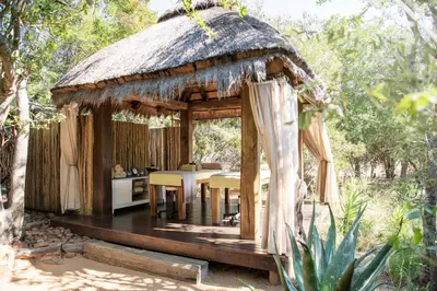 a wooden gazebo with a table and chairs at Jabulani Safari Relais & Chateaux in Kapama Private Game Reserve