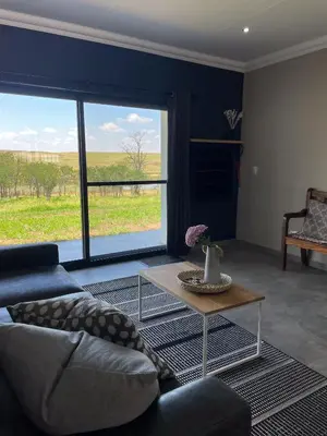 a living room with a couch and a table at Sorgenfri farm stay in Hendrina