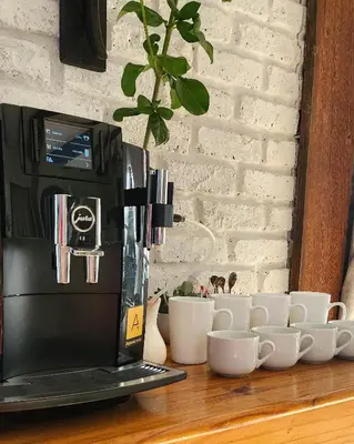 a laptop computer sitting on a wooden table with cups at Waterlily Cove Guesthouse in Pretoria