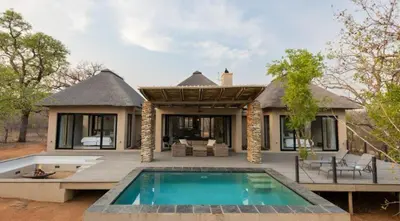 a house with a swimming pool in front of it at Villa Zazu in Hoedspruit