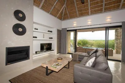 a living room with a couch and a fireplace at Villa Zazu in Hoedspruit