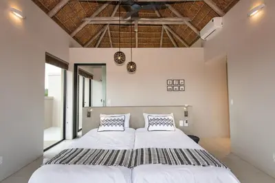 a bedroom with a large white bed with two pillows at Villa Zazu in Hoedspruit