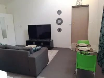 a living room with a couch and a tv at Zenith Guesthouse in Pretoria