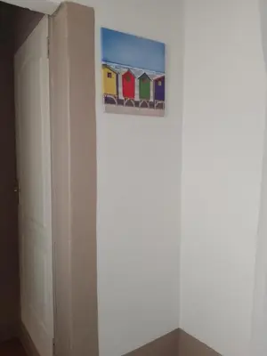 a painting of houses on a wall next to a door at Zenith Guesthouse in Pretoria