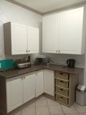 a kitchen with white cabinets and a counter top at Zenith Guesthouse in Pretoria