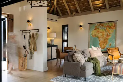 a living room with a couch and a map on the wall at Monwana in Thornybush Game Reserve