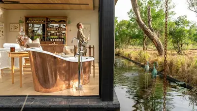 a bath tub in a room with a river at Monwana in Thornybush Game Reserve