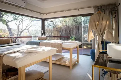 a massage room with two beds and a window at Serondella Safari Lodge in Thornybush Game Reserve