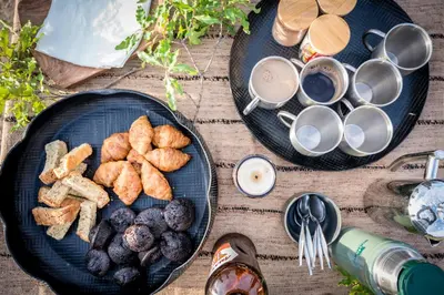two plates of food and cups of coffee on a table at Serondella Safari Lodge in Thornybush Game Reserve