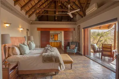 a bedroom with a bed and a living room at Waterbuck Game Lodge Thornybush Nature Reserve in Thornybush Game Reserve