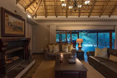 a living room with a couch and a fireplace at Waterbuck Game Lodge Thornybush Nature Reserve in Thornybush Game Reserve