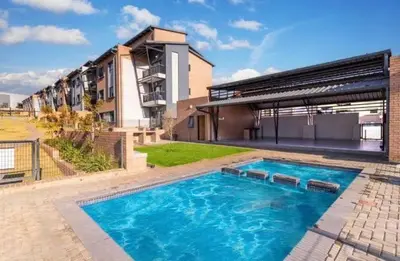a large swimming pool in front of a building at The Waterfall Nest 2 Bedroom Apartment in Midrand