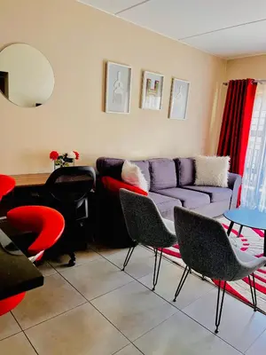 a living room with a purple couch and chairs at The Waterfall Nest 2 Bedroom Apartment in Midrand